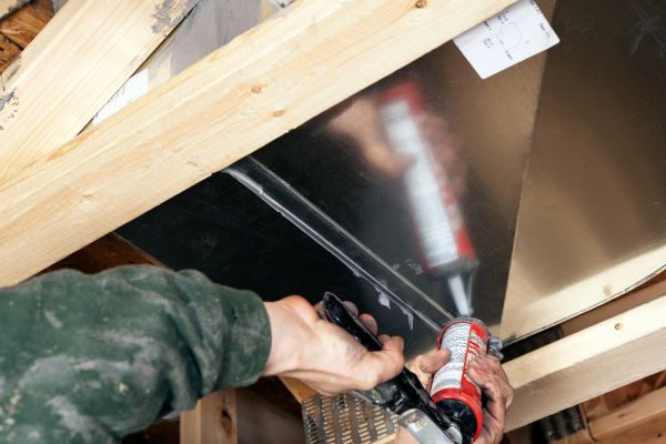Technician doing HVAC ductwork repair.